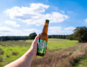 De Groene Buizerd bierflesje vast in de natuur